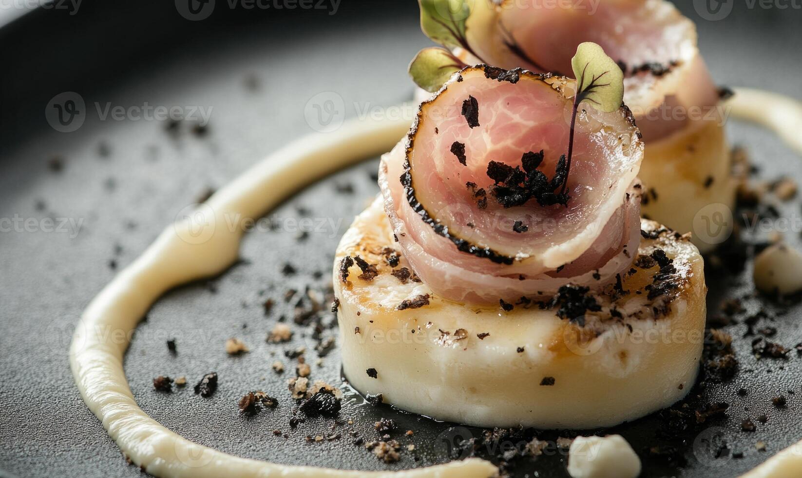 A plate of food with a white sauce and a garnish of black pepper photo