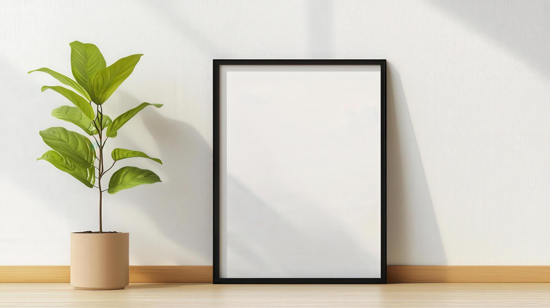 A black framed white picture sits on a wooden floor next to a potted plant photo