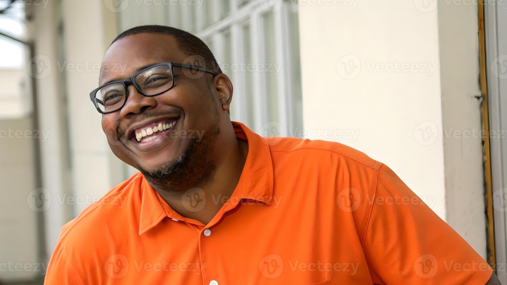 Happy Man in Orange Shirt Smiling Outdoors photo
