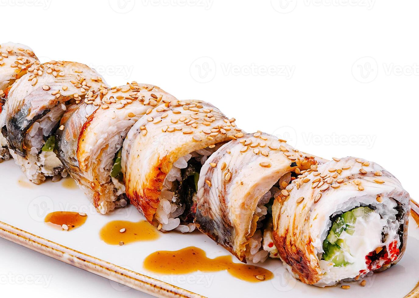 Freshly prepared sushi rolls with sesame and sauce on a platter photo
