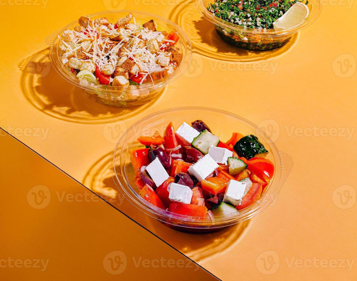 Fresh salads displayed on a vibrant yellow table photo
