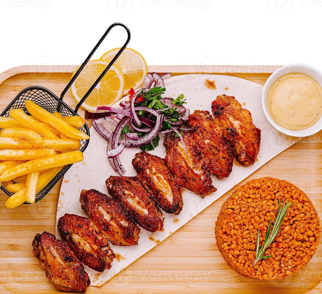 Spicy grilled chicken wings served with fries and rice photo