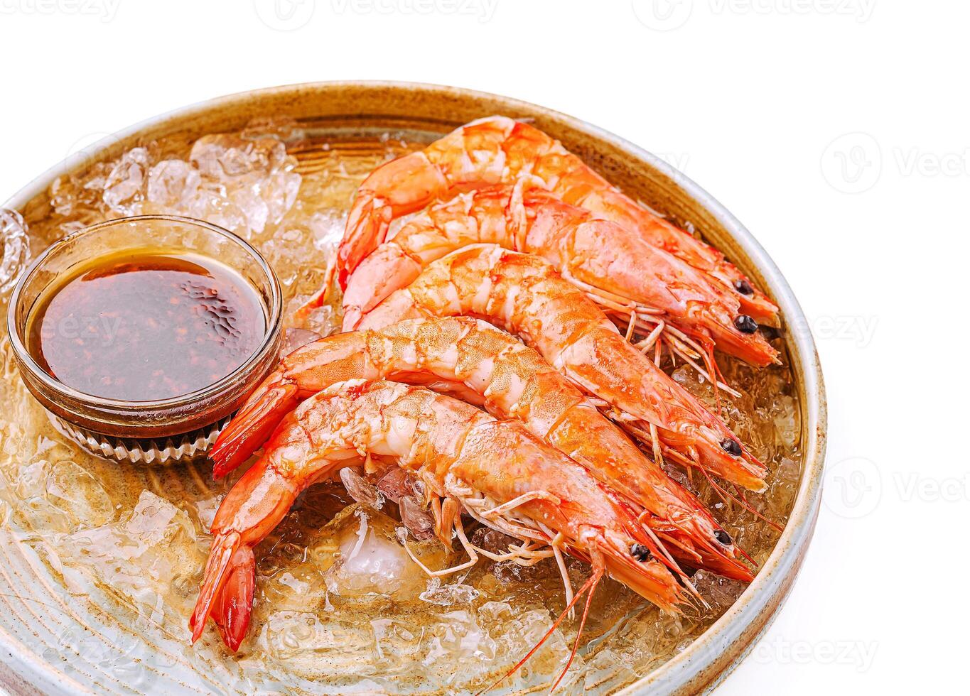 Fresh shrimp served with dipping sauce on ice platter photo