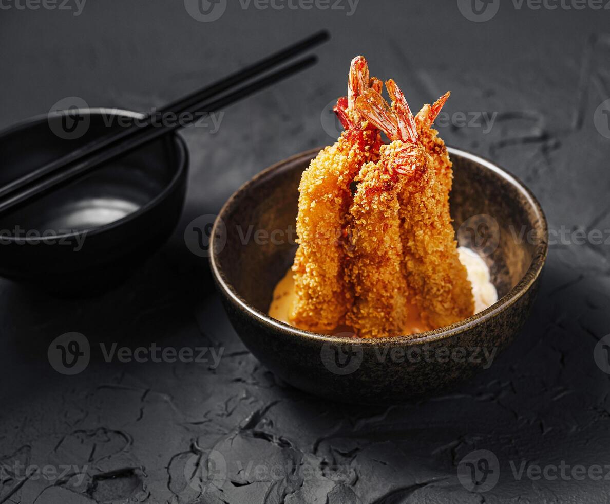 Shrimp tempura served in a small bowl with chopsticks nearby photo