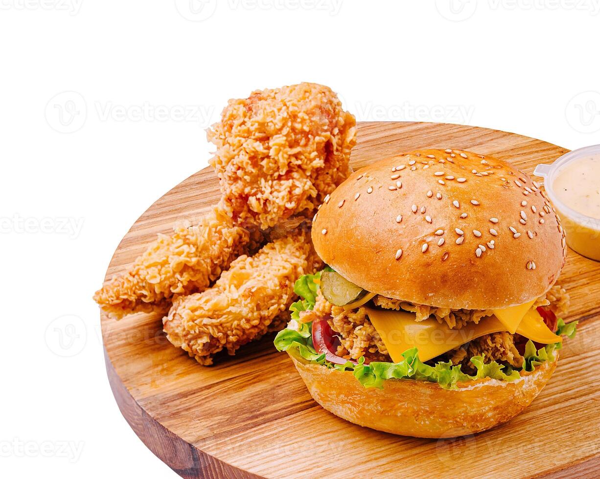 Crispy fried chicken sandwich with sides on wooden platter photo
