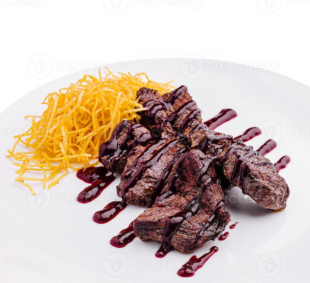 Grilled steak served with crispy potatoes and berry sauce photo