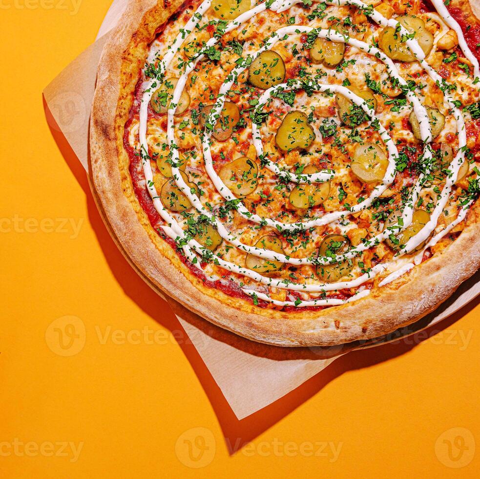Unique pizza topped with pickles and sauce on vibrant background photo
