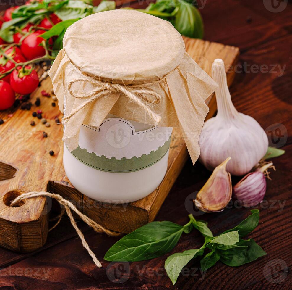 Homemade garlic sauce with fresh ingredients on a wooden table photo