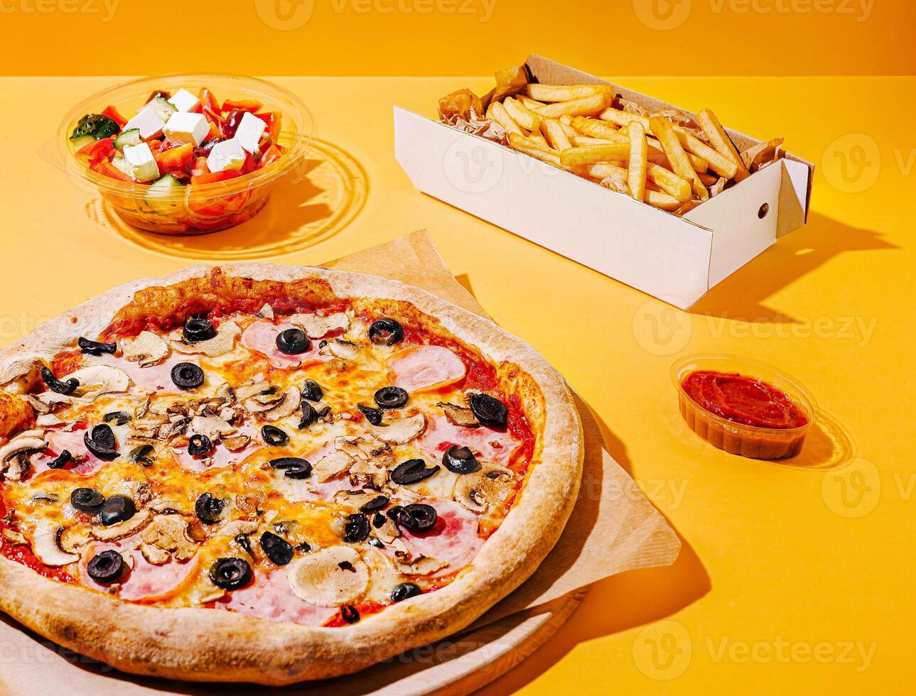 Delicious pizza with salad and fries on vibrant background photo