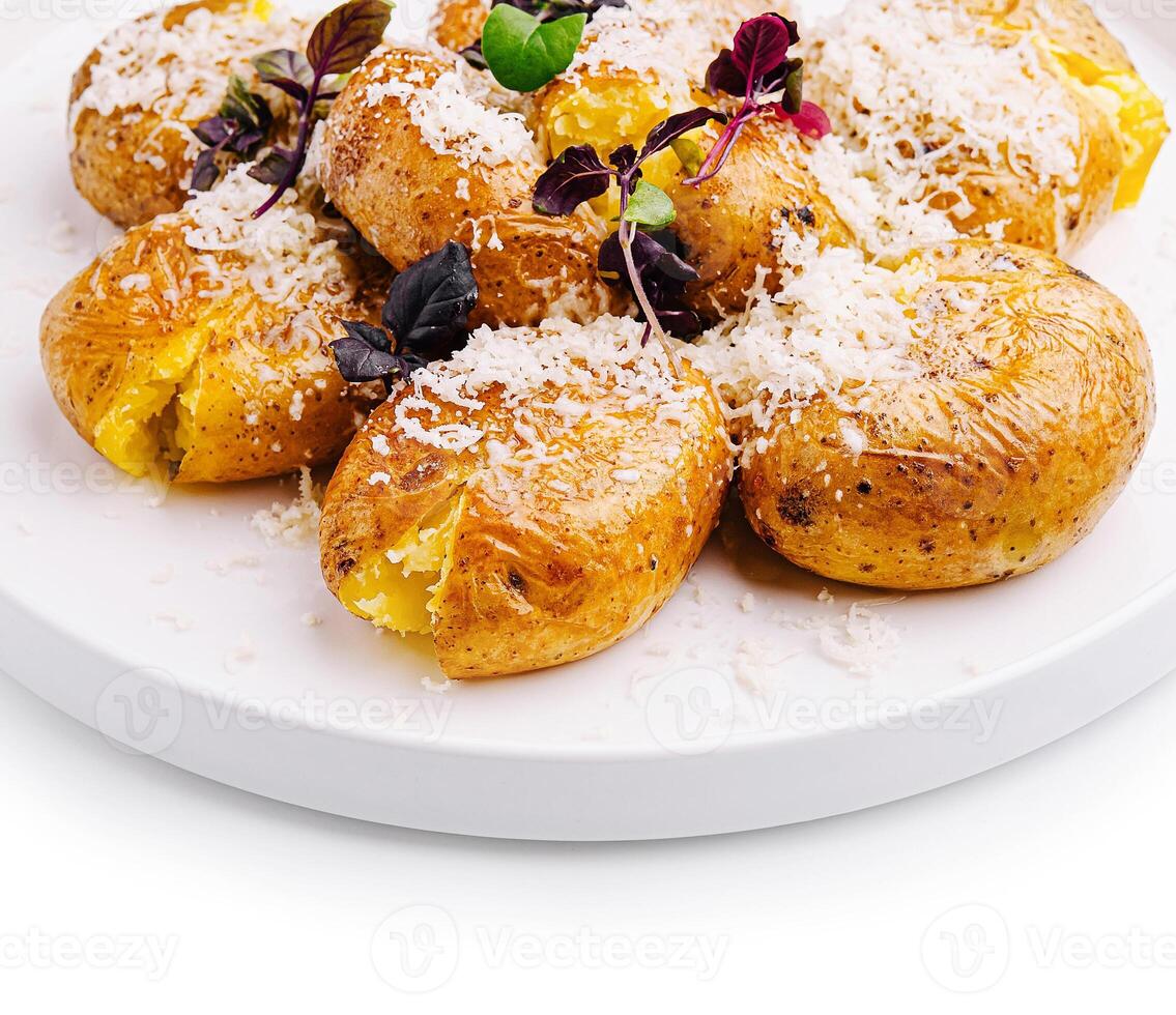 Savory baked potatoes topped with cheese and herbs on a plate photo