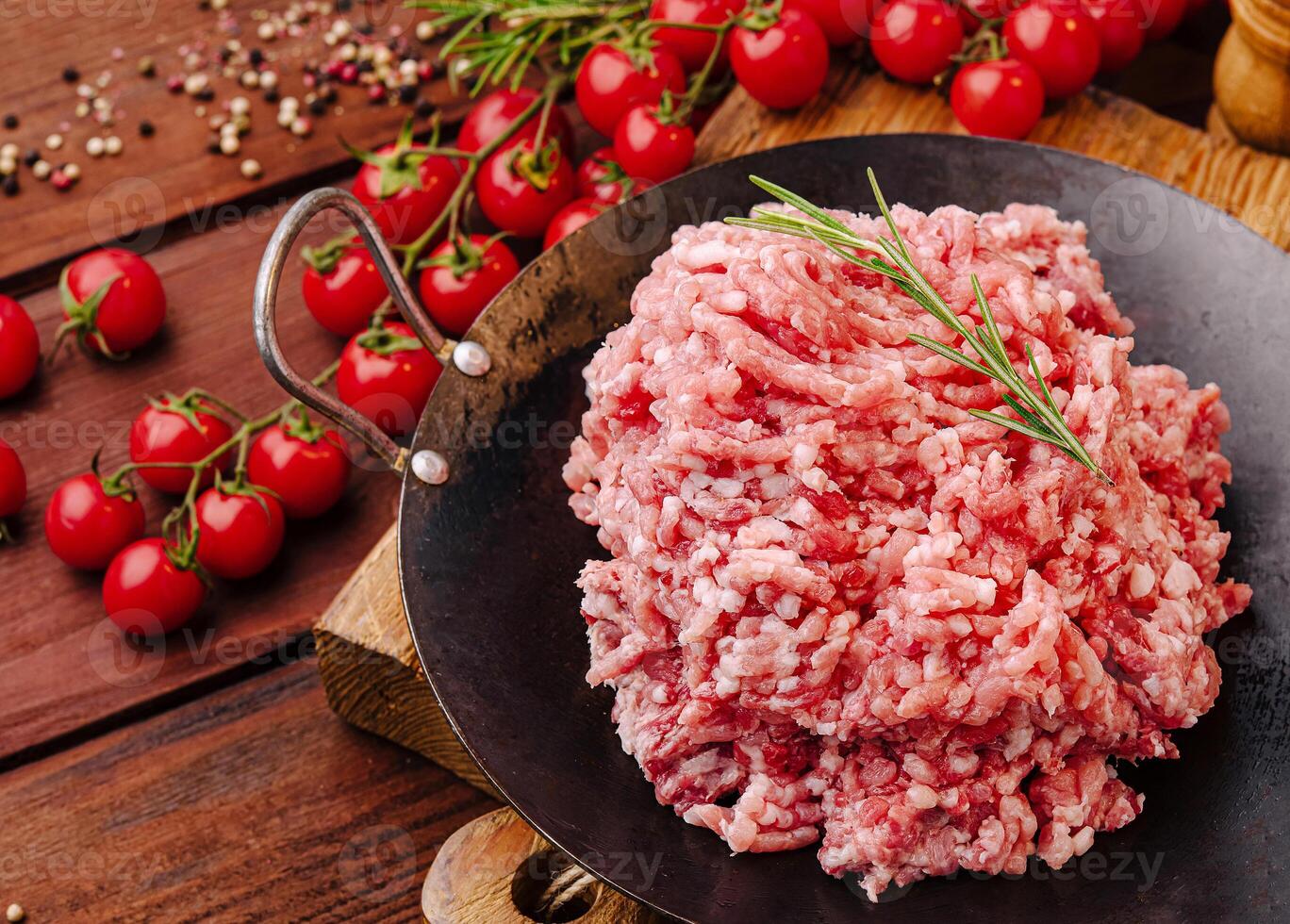 Fresh ground meat prepared for cooking with cherry tomatoes photo