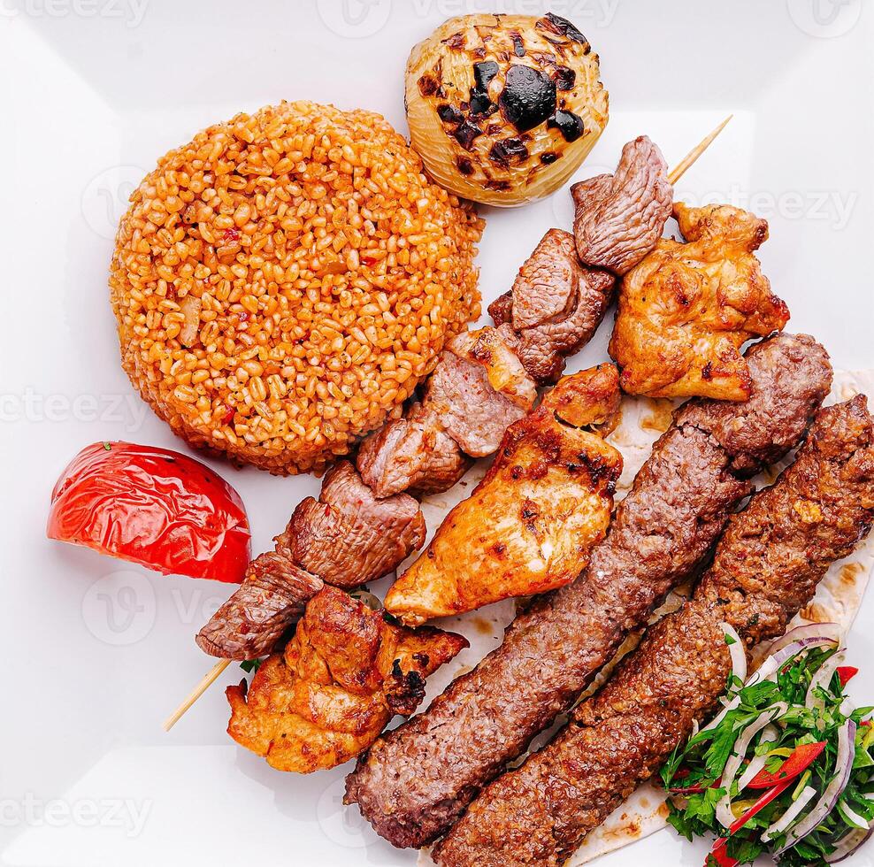 Grilled skewers served with spiced rice and vegetables at dinner photo