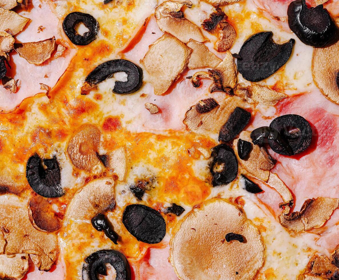 Savory pizza with olives and mushrooms on a wooden table photo