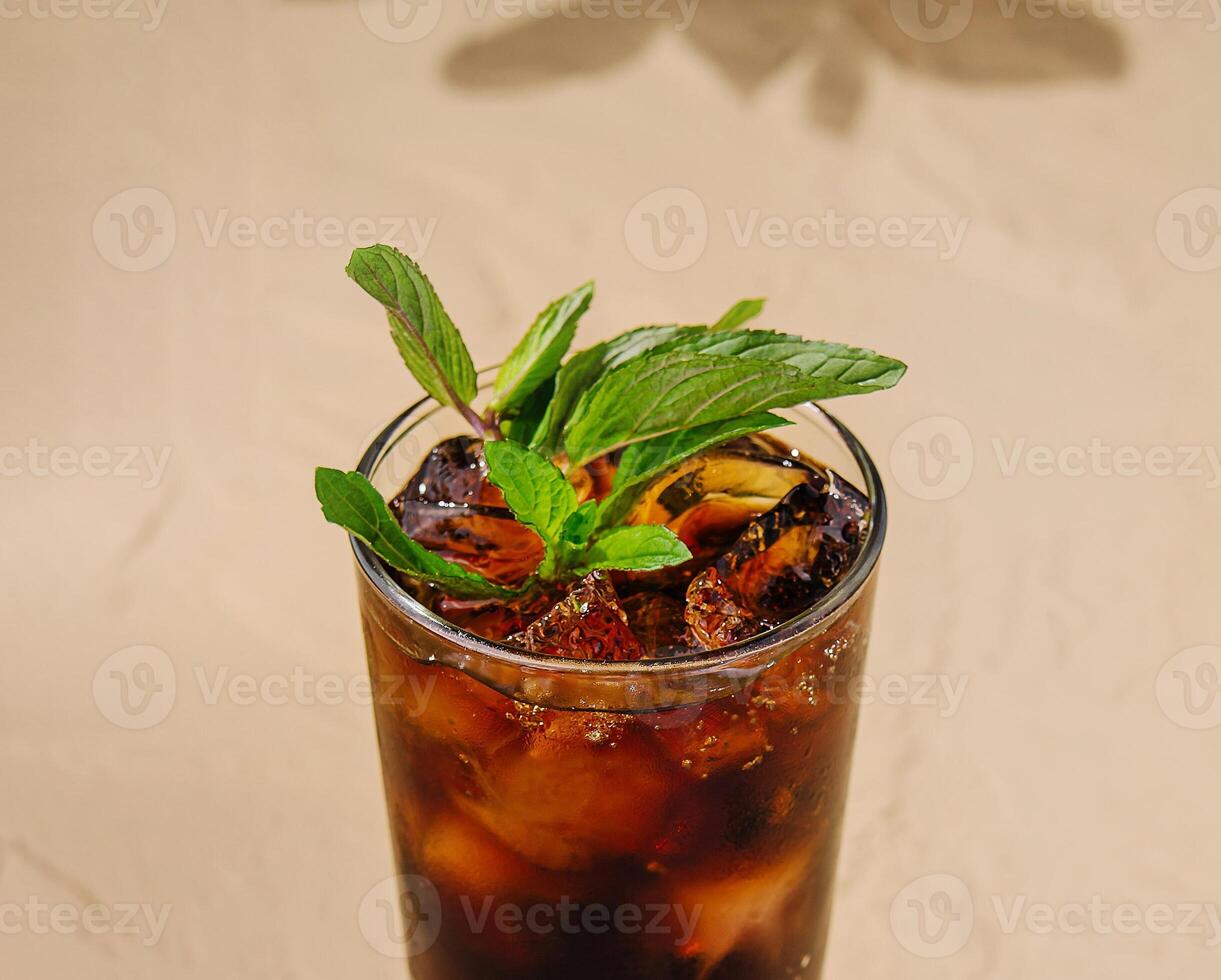 Refreshing ice cold cola with mint leaves on a table photo
