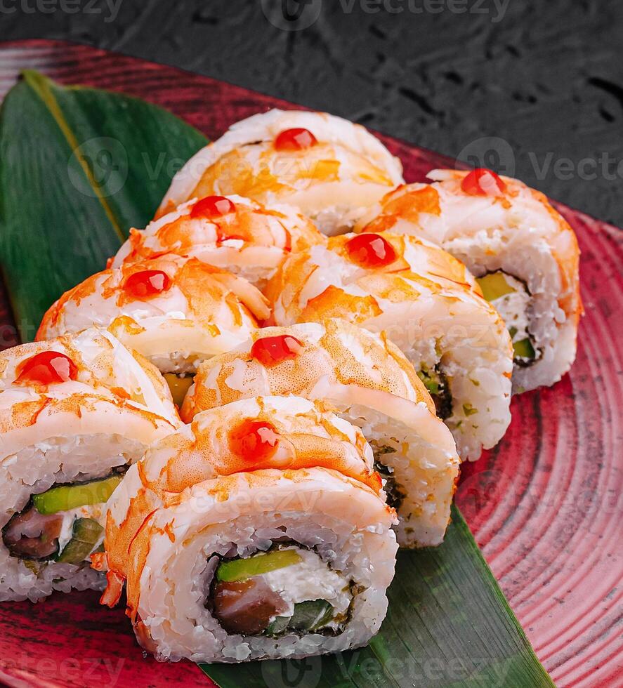 Sushi rolls displayed artistically with vibrant toppings on plate photo