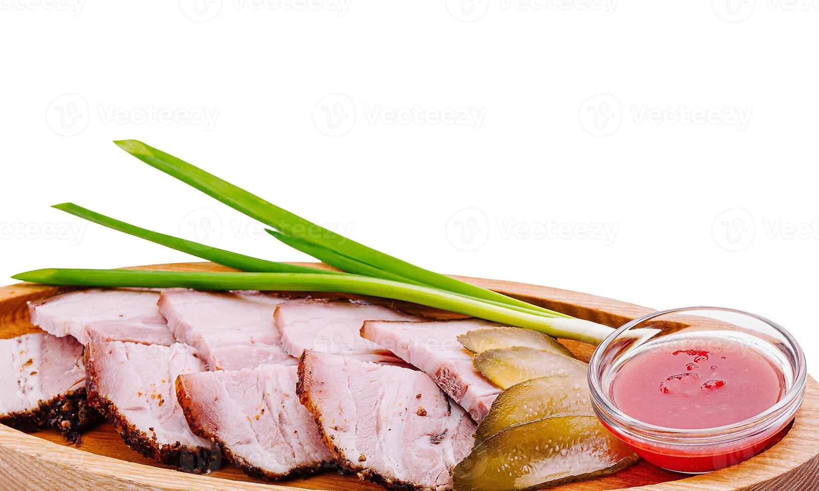 Delicious platter of sliced meat with green onions and sauce photo