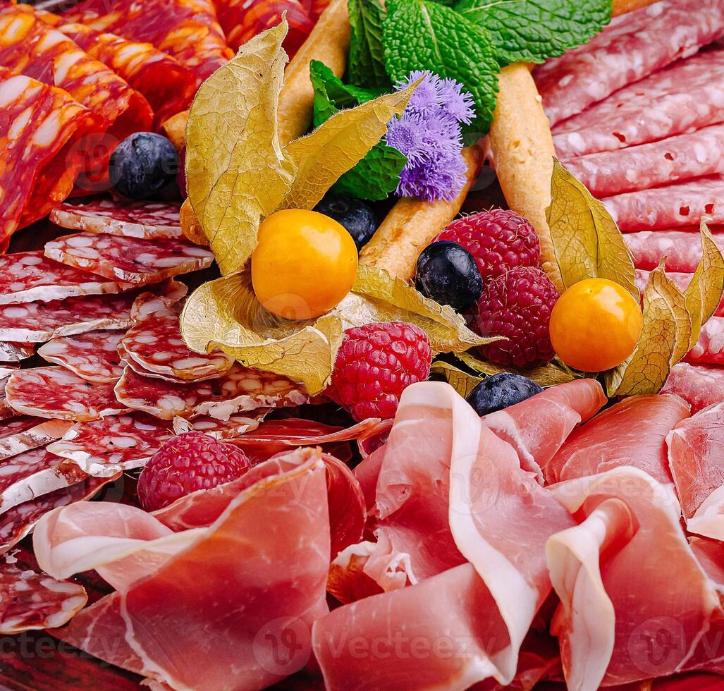 Artfully arranged charcuterie board with assorted meats and fruits photo
