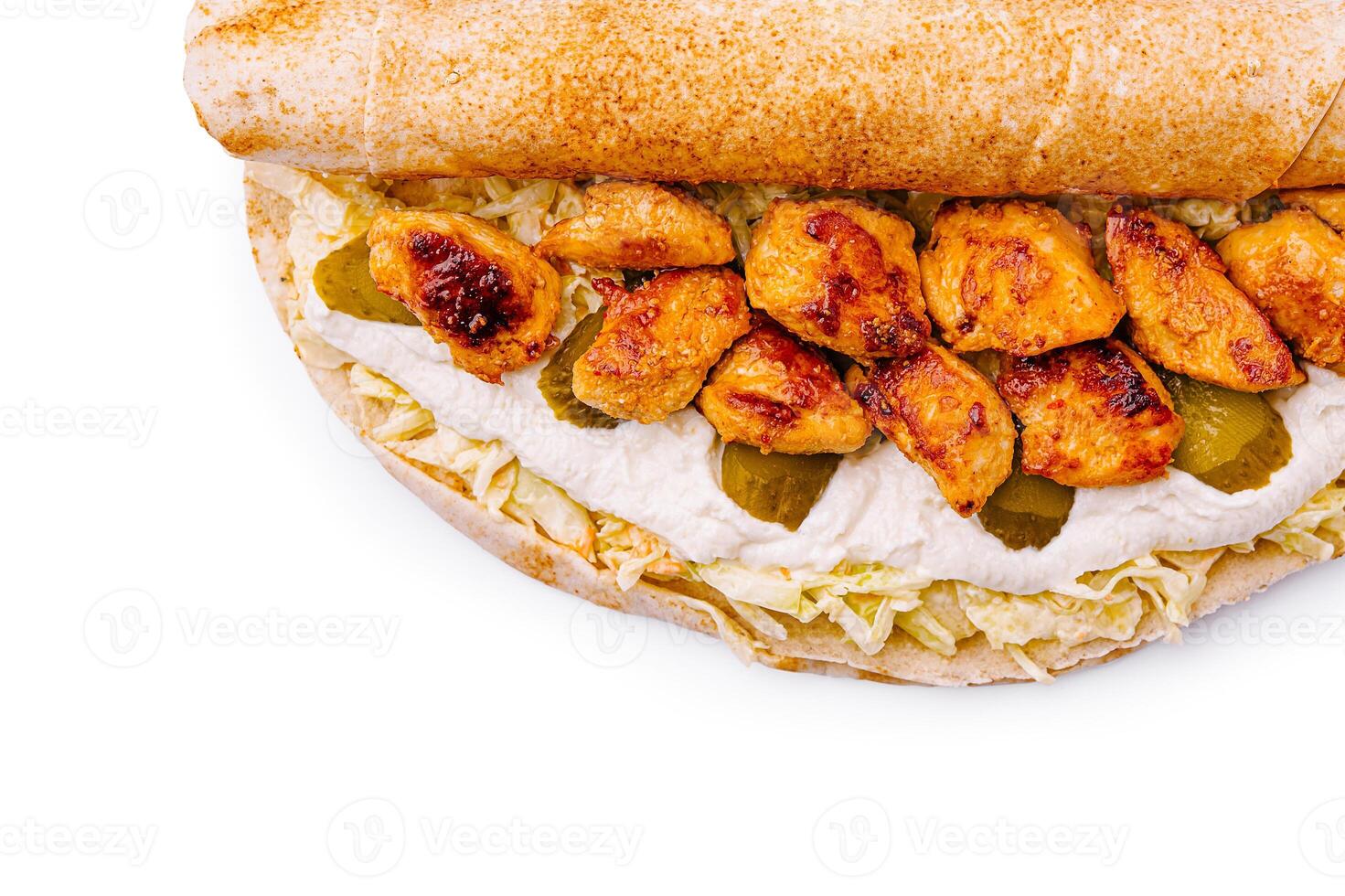 Chicken wrap with creamy sauce and pickles served on a flatbread photo