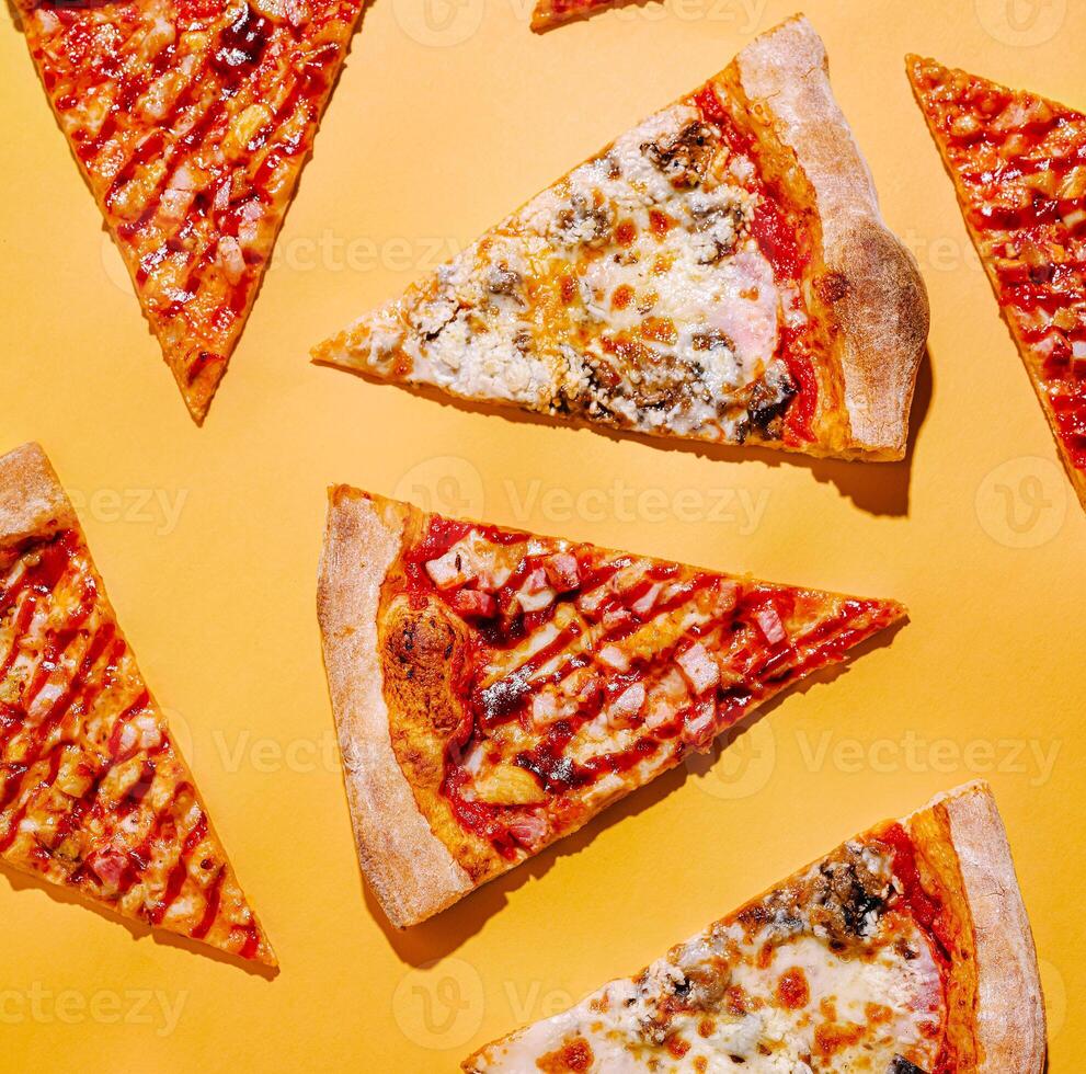 Slices of pizza arranged on a bright yellow background photo