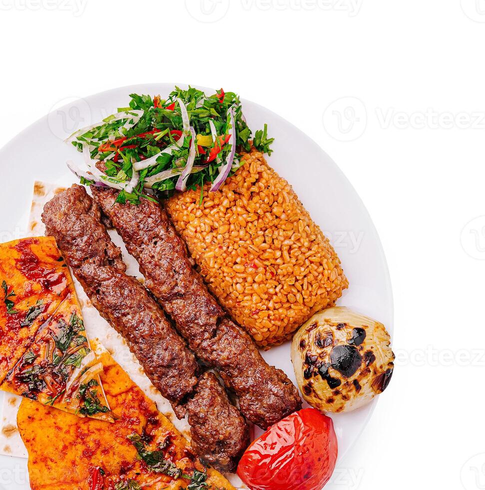 Delicious grilled kebabs with flavorful rice and fresh vegetables photo