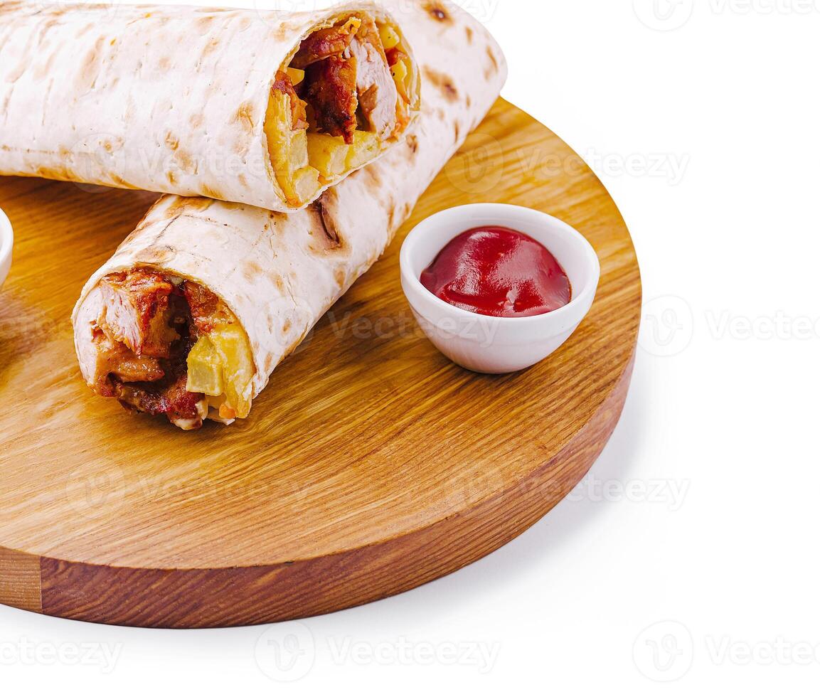 Delicious wraps served with sauce on a wooden board photo