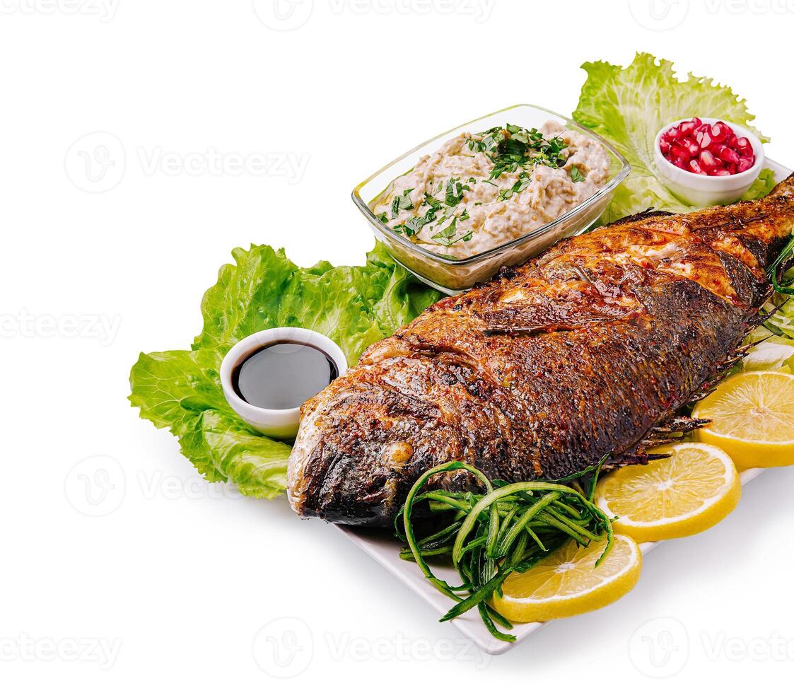 Deliciously grilled whole fish served with fresh sides and dips photo