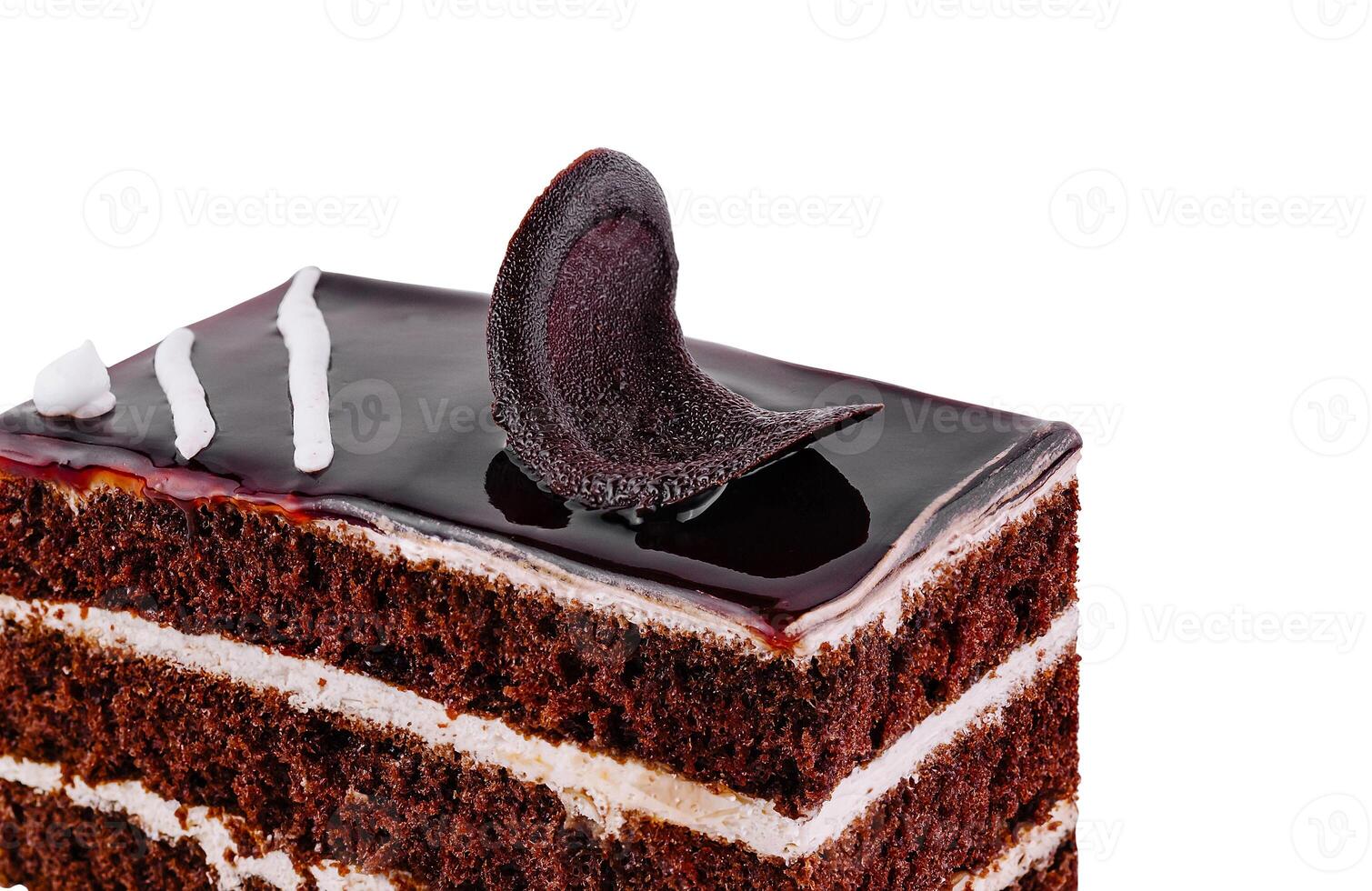 Chocolate cake slice decorated with chocolate curls and glaze on white background photo