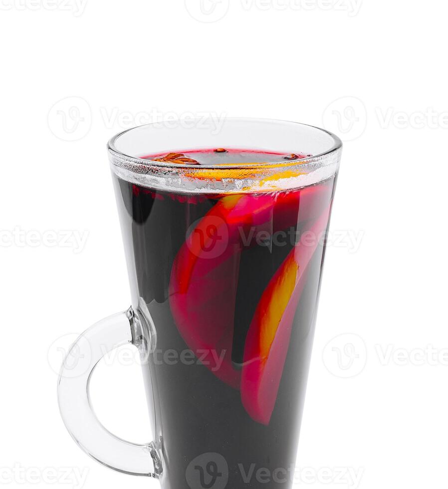 Warm beverage with citrus and fruit slices in a glass cup photo
