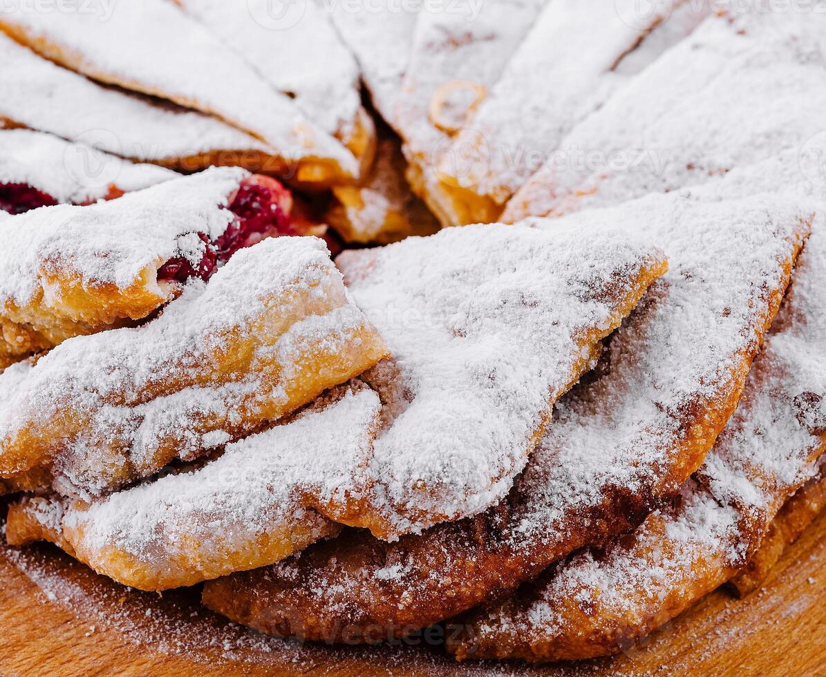 Freshly baked cherry pie with sugar powder on a wooden board photo
