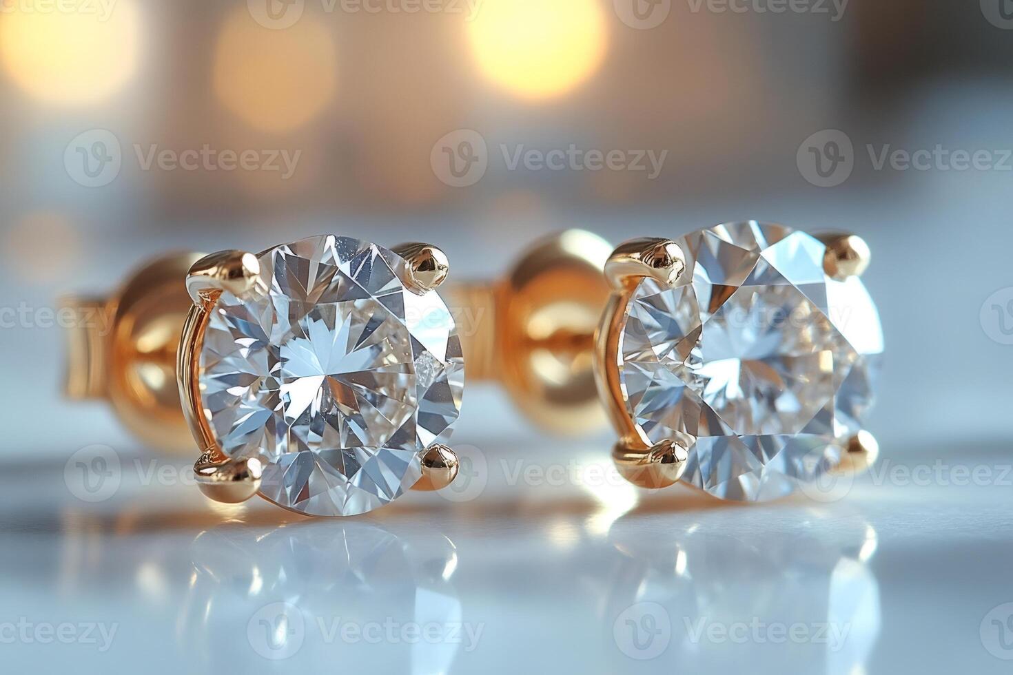 Pair of sparkling diamond earrings reflecting golden lights photo