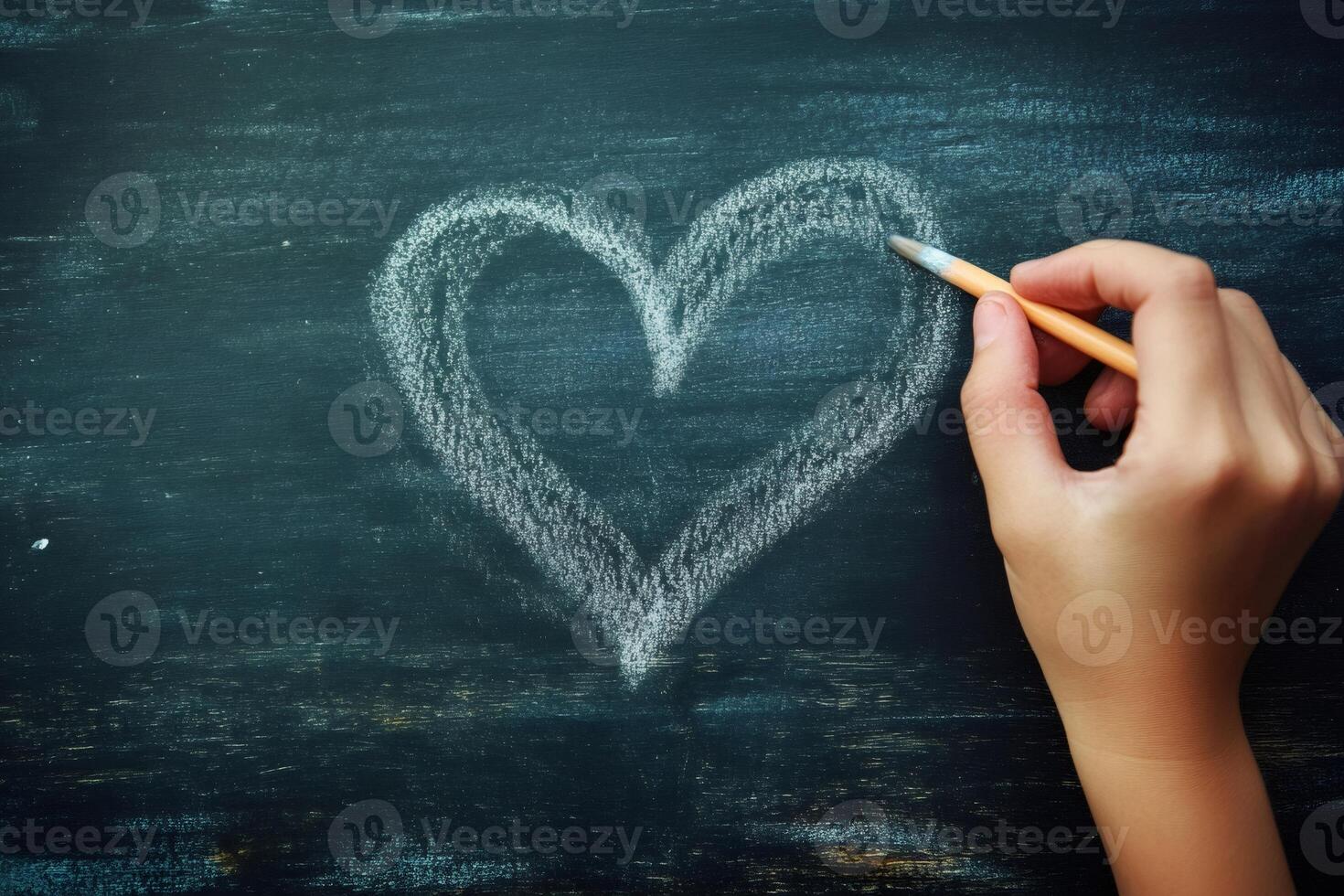 Hand drawing heart shape on chalkboard surface photo