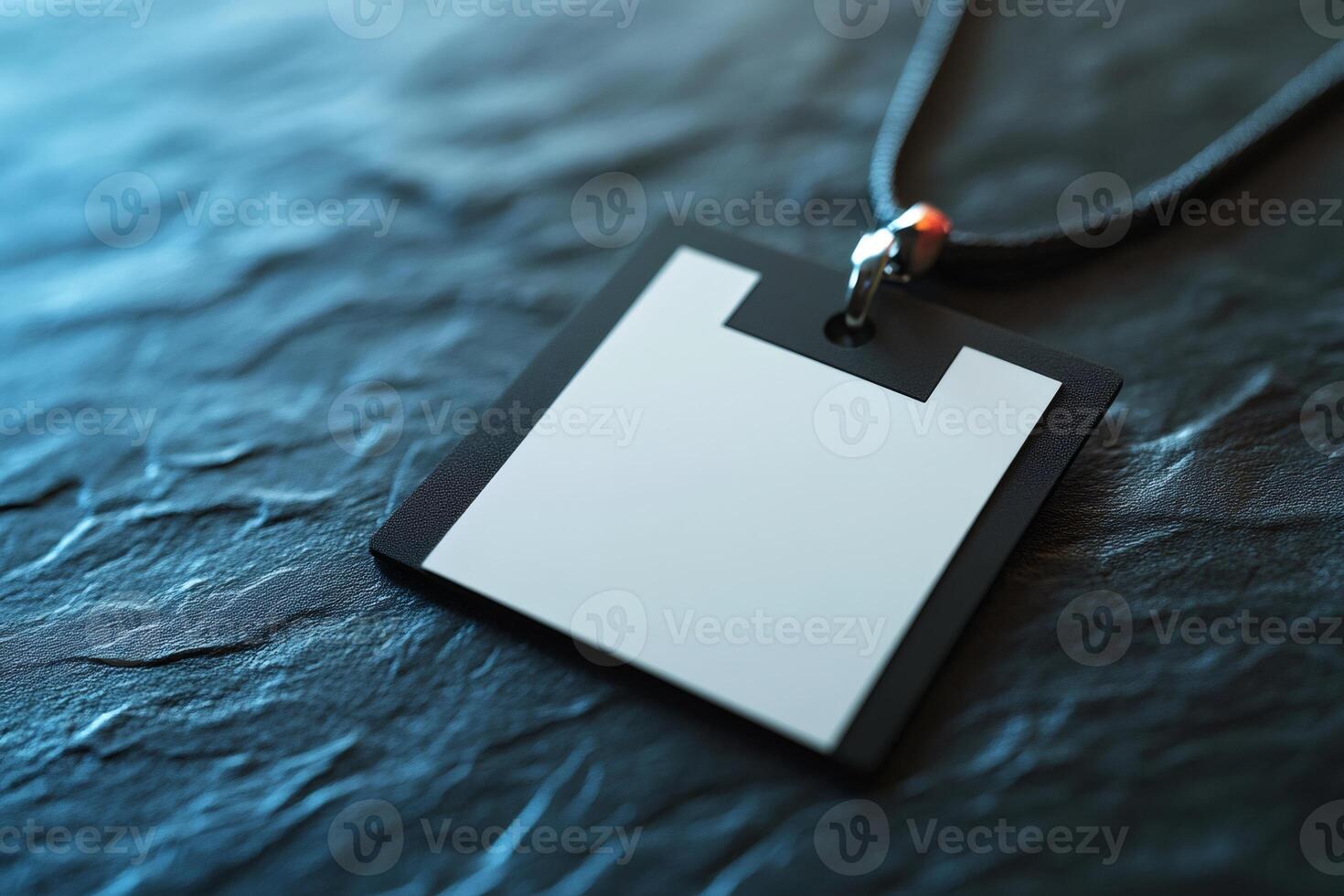 Blank white id card or name tag resting on dark stone surface photo