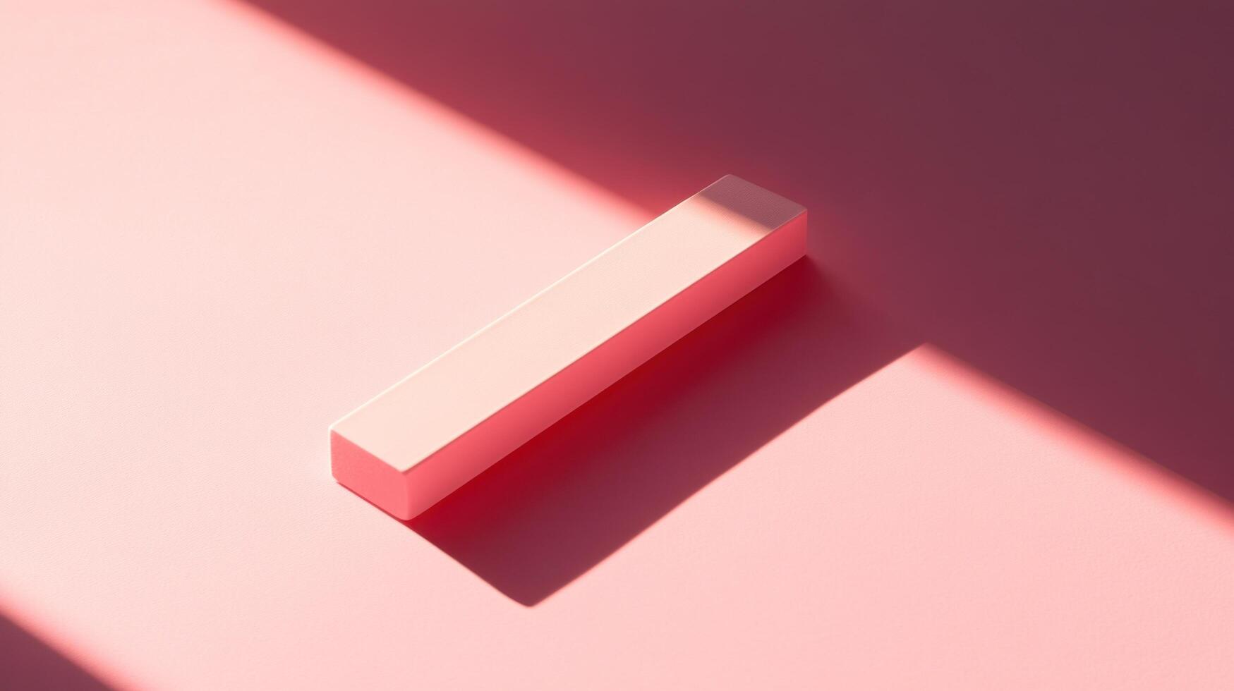 A single, light pink, rectangular prism sits on a pale pink surface, casting a shadow from a bright light source. photo