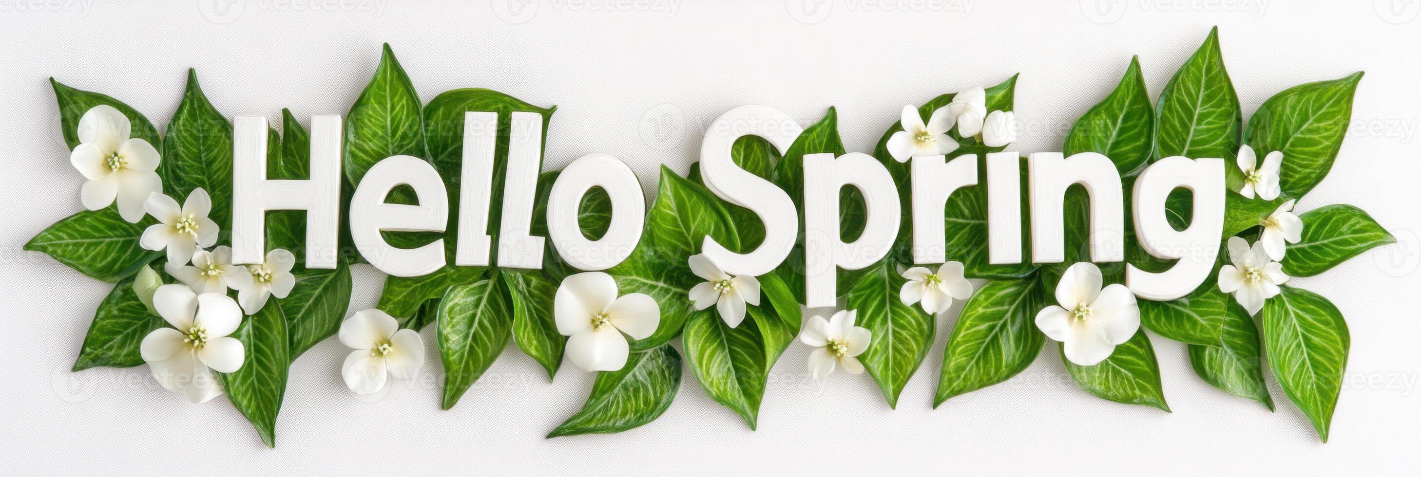 Greeting the arrival of spring with vibrant leaves and delicate white flowers decorating cheerful letters photo