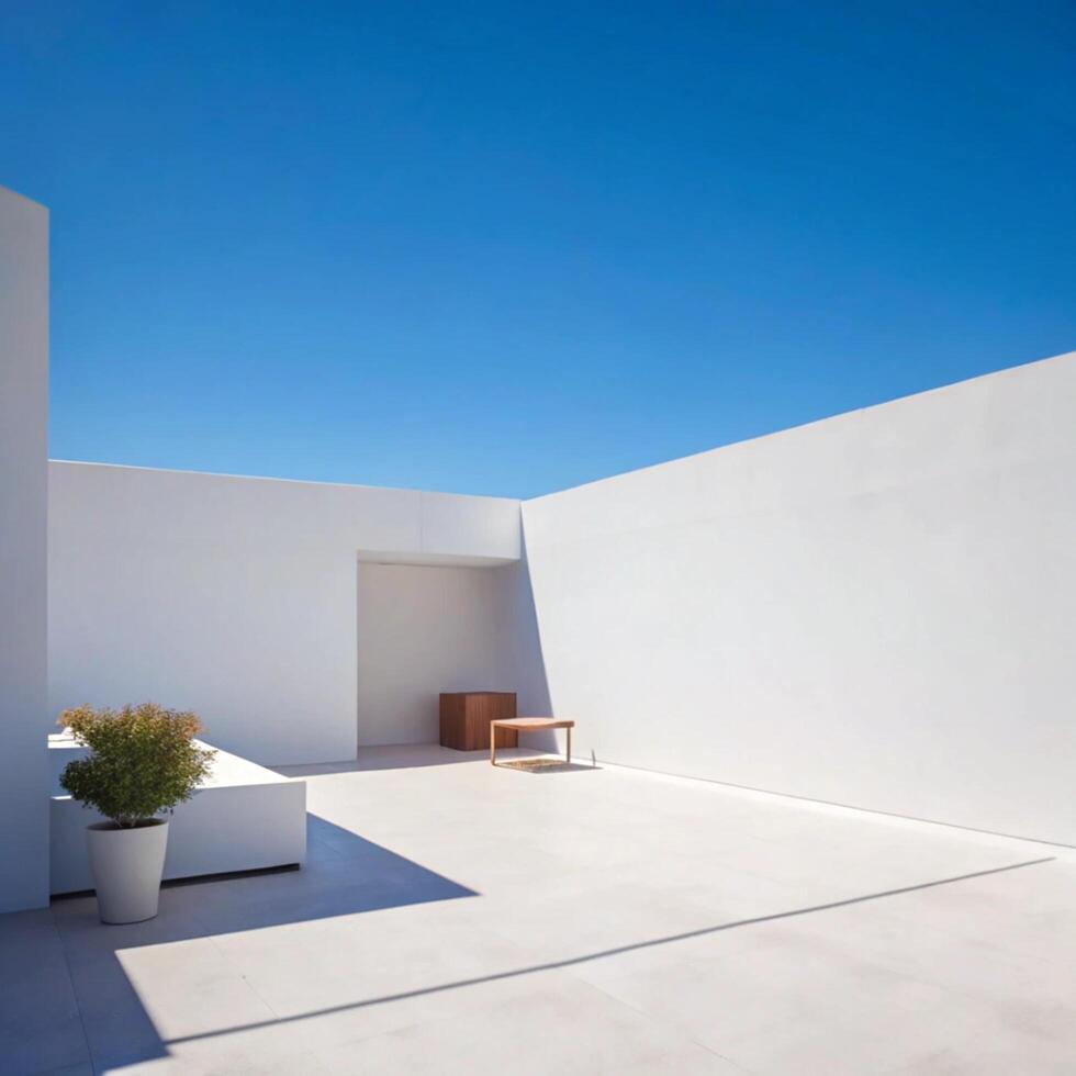 Minimalist White Courtyard with Wooden Table and Seating under Bright Blue Sky photo