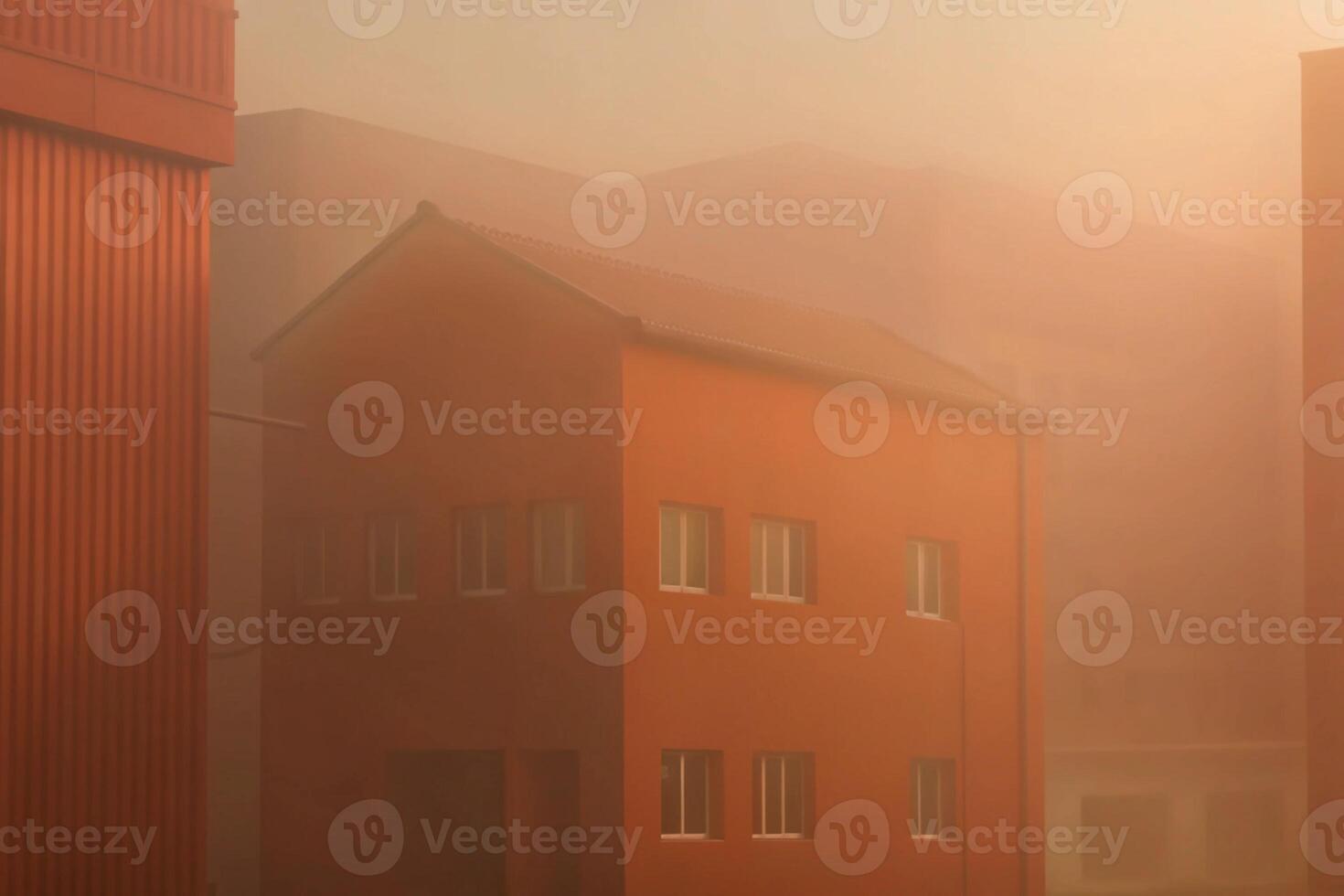 A building is shown in the fog with a red roof photo