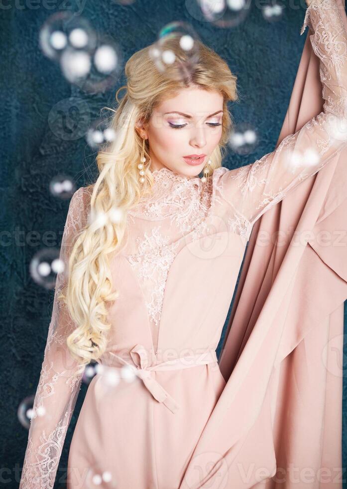 Portrait of young beautiful caucasian blond girl in pink dress photo