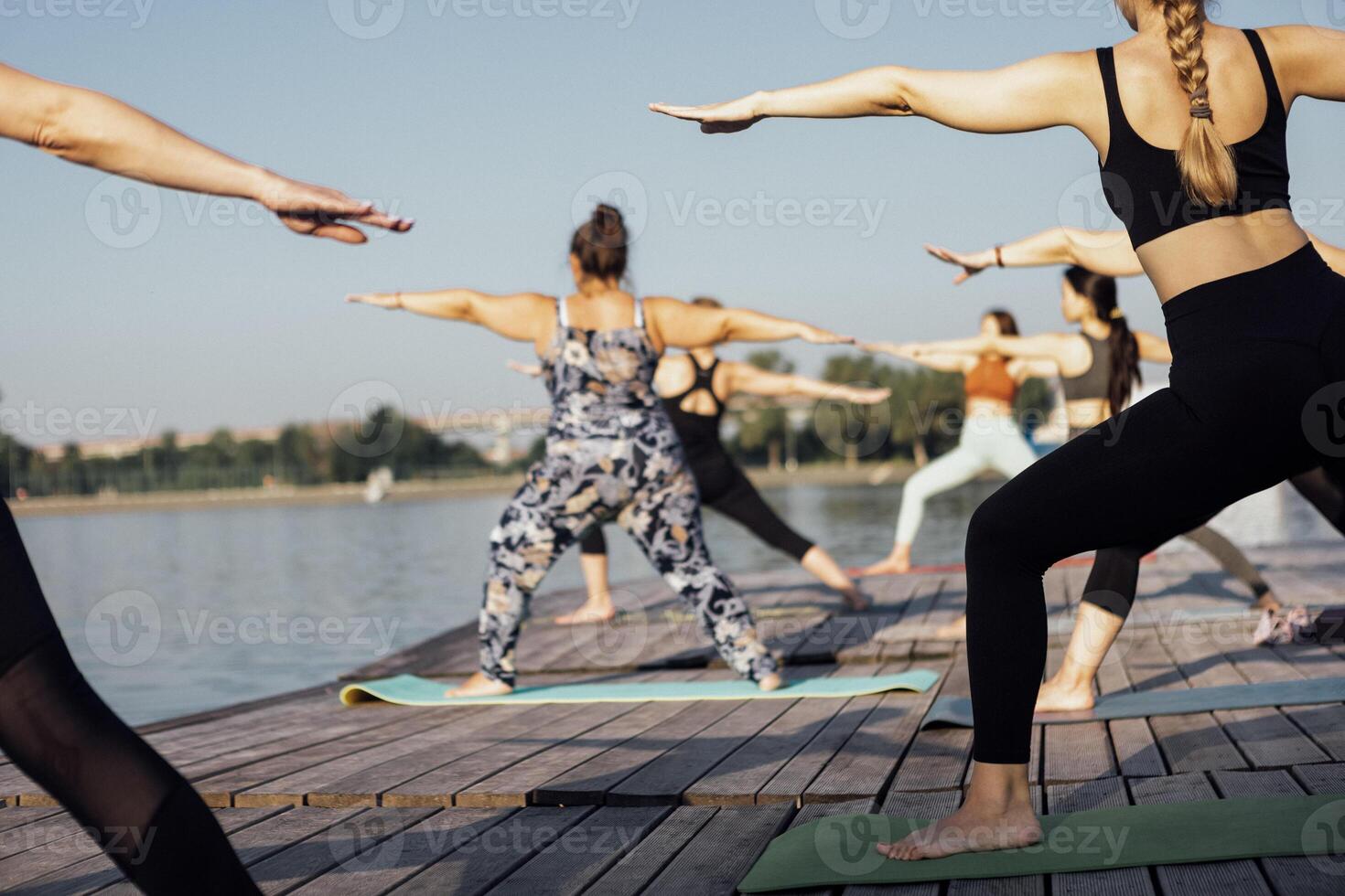 Yoga class with an instructor at the pier on the river photo