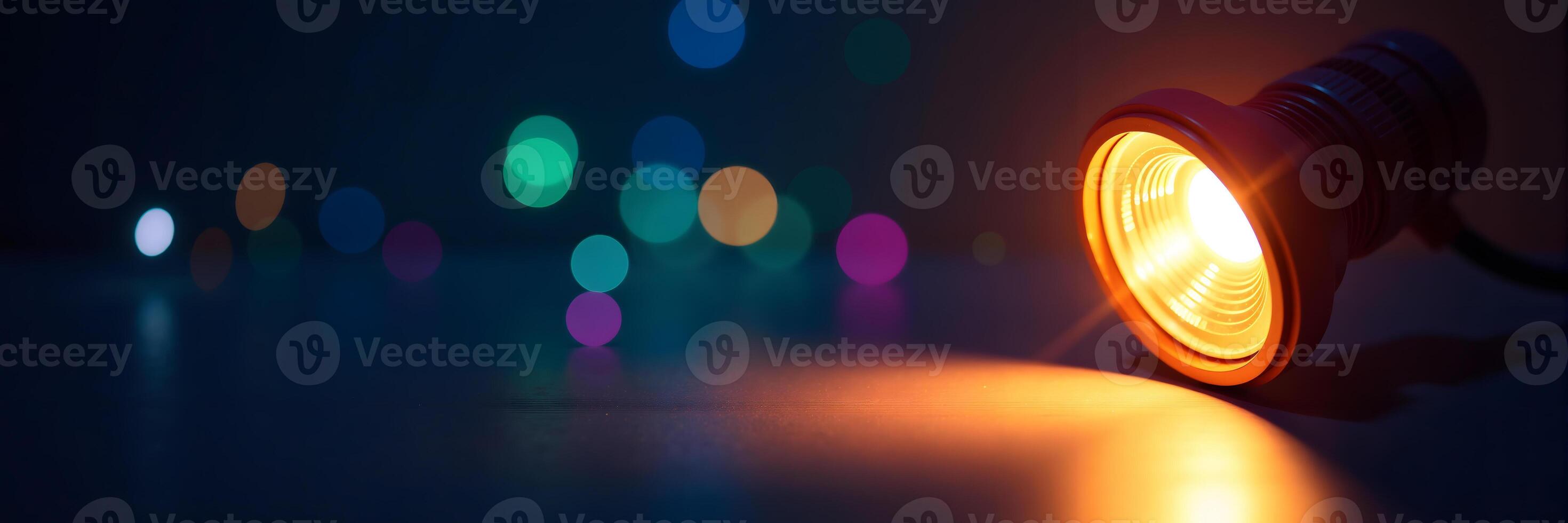 Illuminated Lightbulb with Colorful Bokeh Background photo