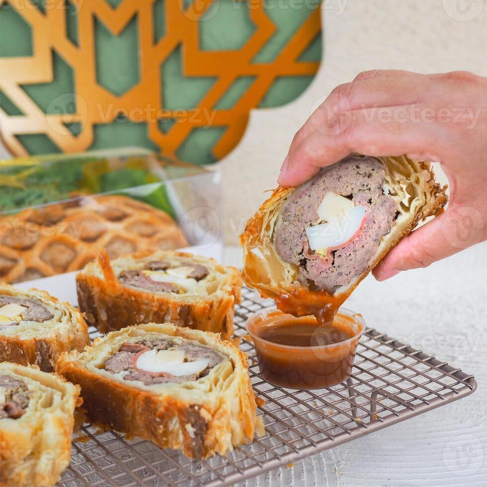People Hand Dipping Cake Into Sauce with Ramadan and EID Mubarak Theme photo