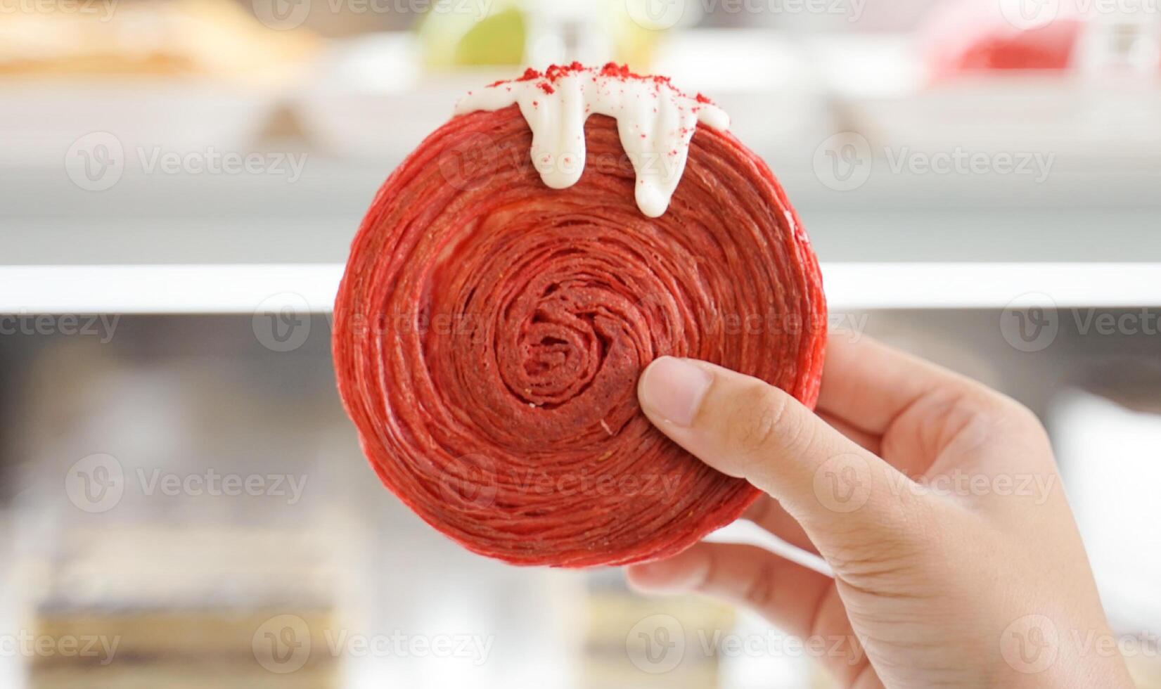Ladies Hand Holding Red Velvet Cromboloni pastry photo