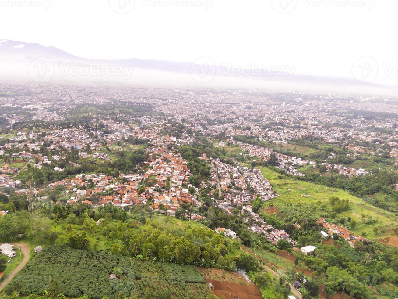 Aerial Landscape view of foggy sky above mountains at dawn. High angle view of Mountain and cityscape in valley. Panorama of Highland in Bandung. photo