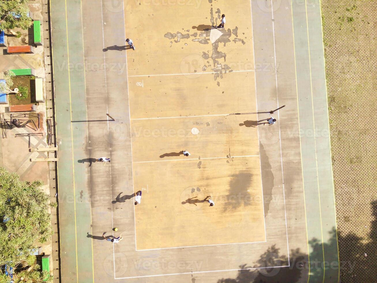 drone shot of Football Game on futsal field. Top view of boys having fun playing football in Cicalengka Square. Playing ball on cement field. Sports Activity photographed from above. photo