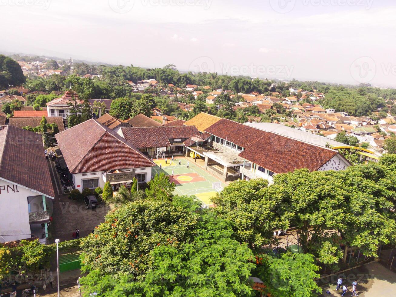 Aerial view of a soccer field in the middle of a brown-roofed building. Drone Landscape of an elite school, photographed from above. Wide angle panoramic photo suitable for web banner