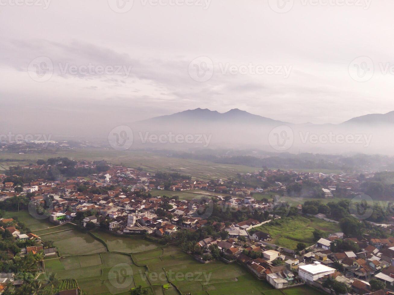 Bandung. Aerial Landscape view of foggy sky above mountains at dawn. High angle view of Mountain and cityscape in valley. Panorama of Highland in Bandung. Asia photo