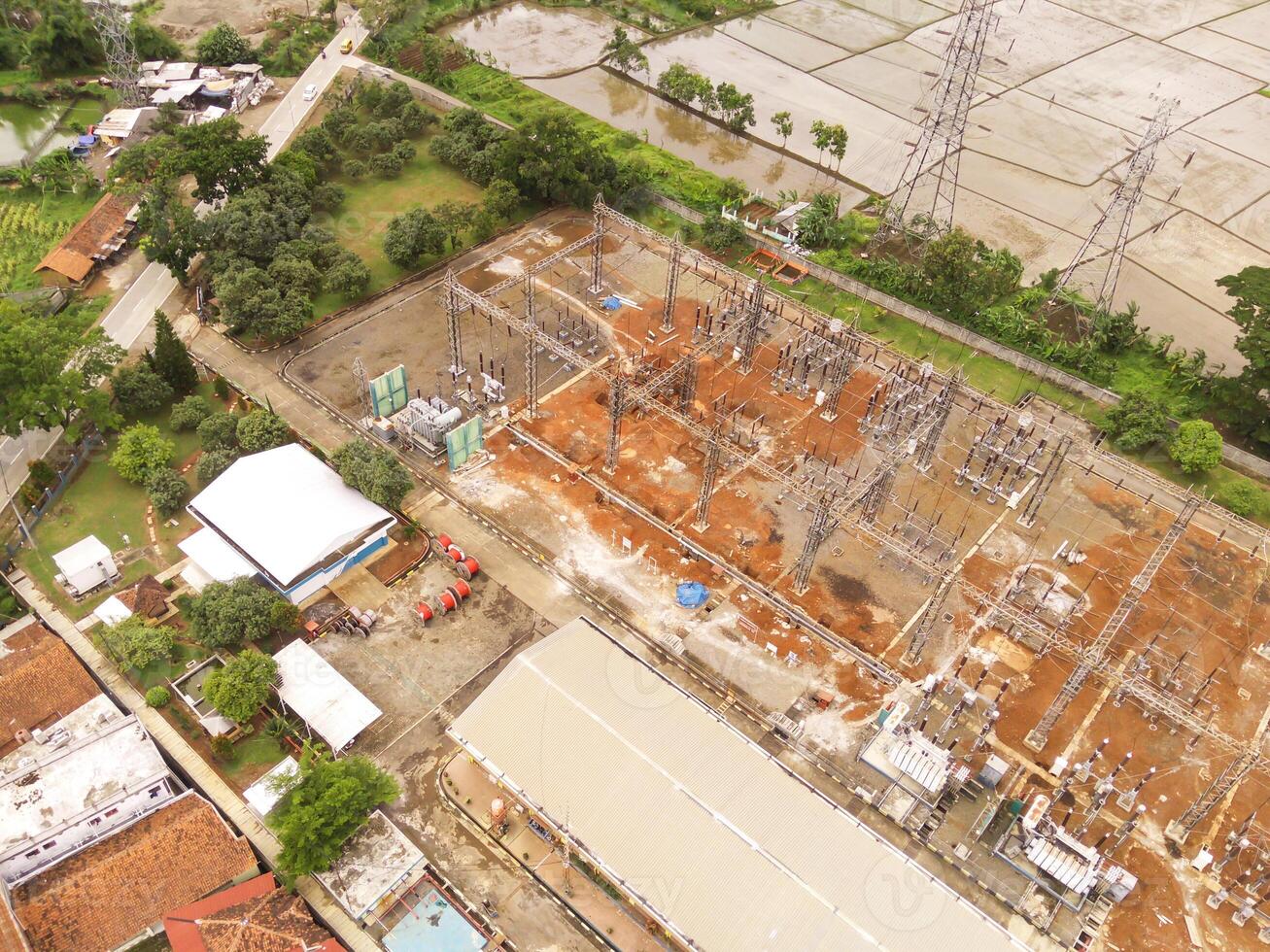 Cikancung, Indonesia. Aerial Landscape view of electric power distribution station to the entire district. High angle view of electric tower and agricultural fields. Panorama of Electricity industry. photo