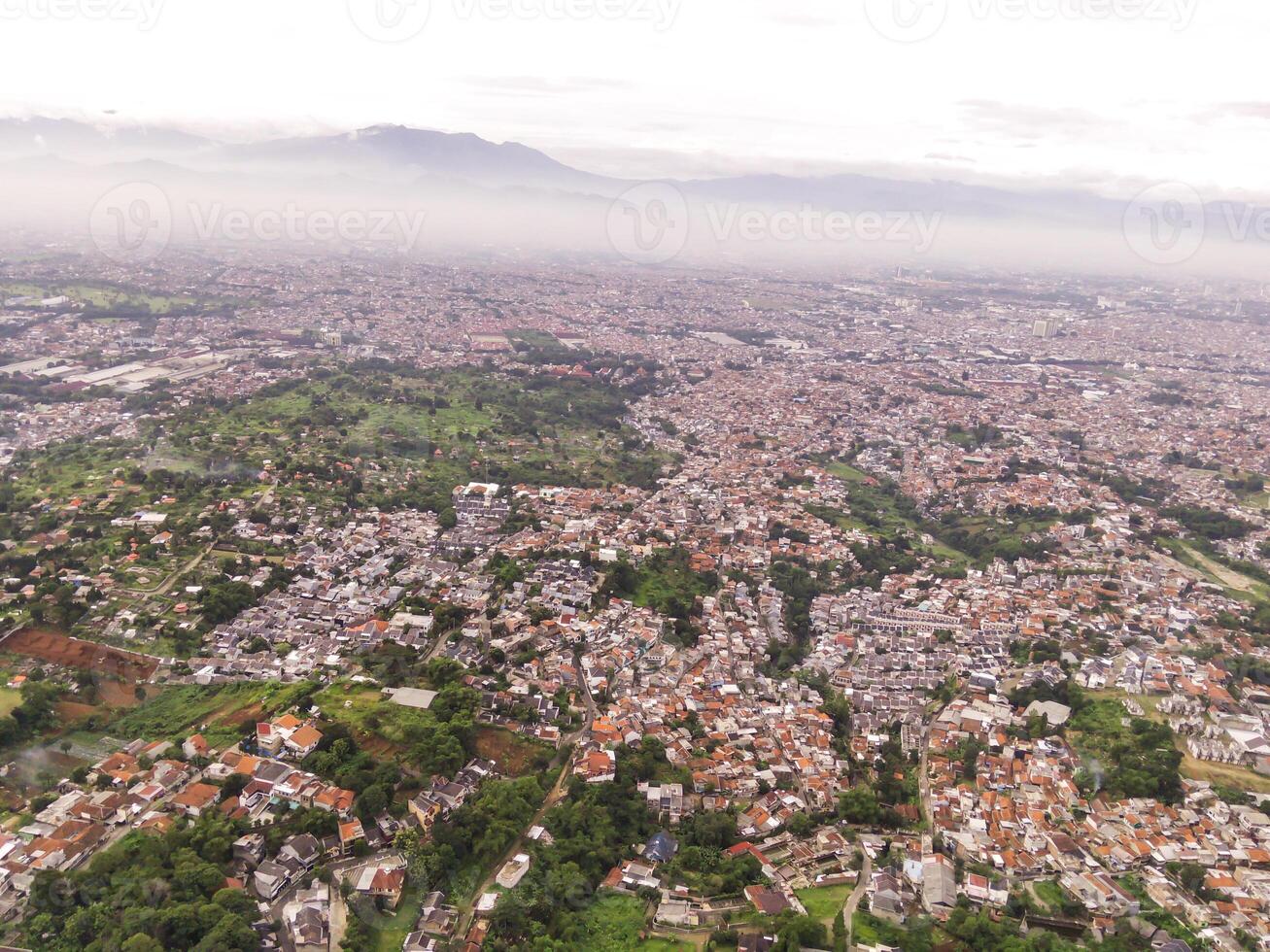 Residential District and Neighborhood in foggy morning. Suburbs of Bandung in West Java, Indonesia, photographed from above. Wide angle panoramic photo suitable for web banners