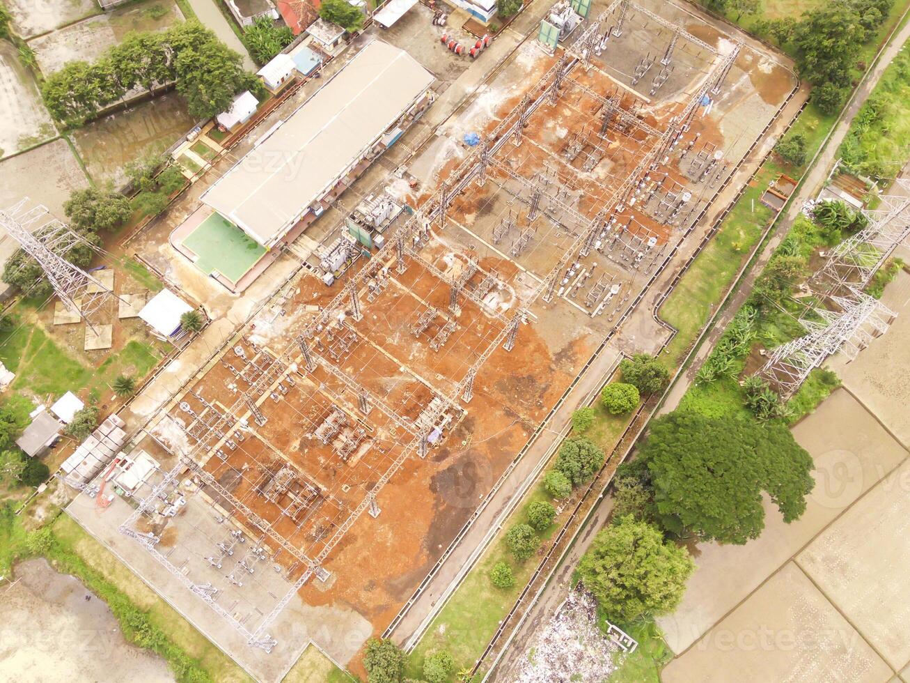 Indonesia. Aerial Landscape view of electric power distribution station to the entire district. High angle view of electric tower and agricultural fields. Panorama of Electricity industry. photo