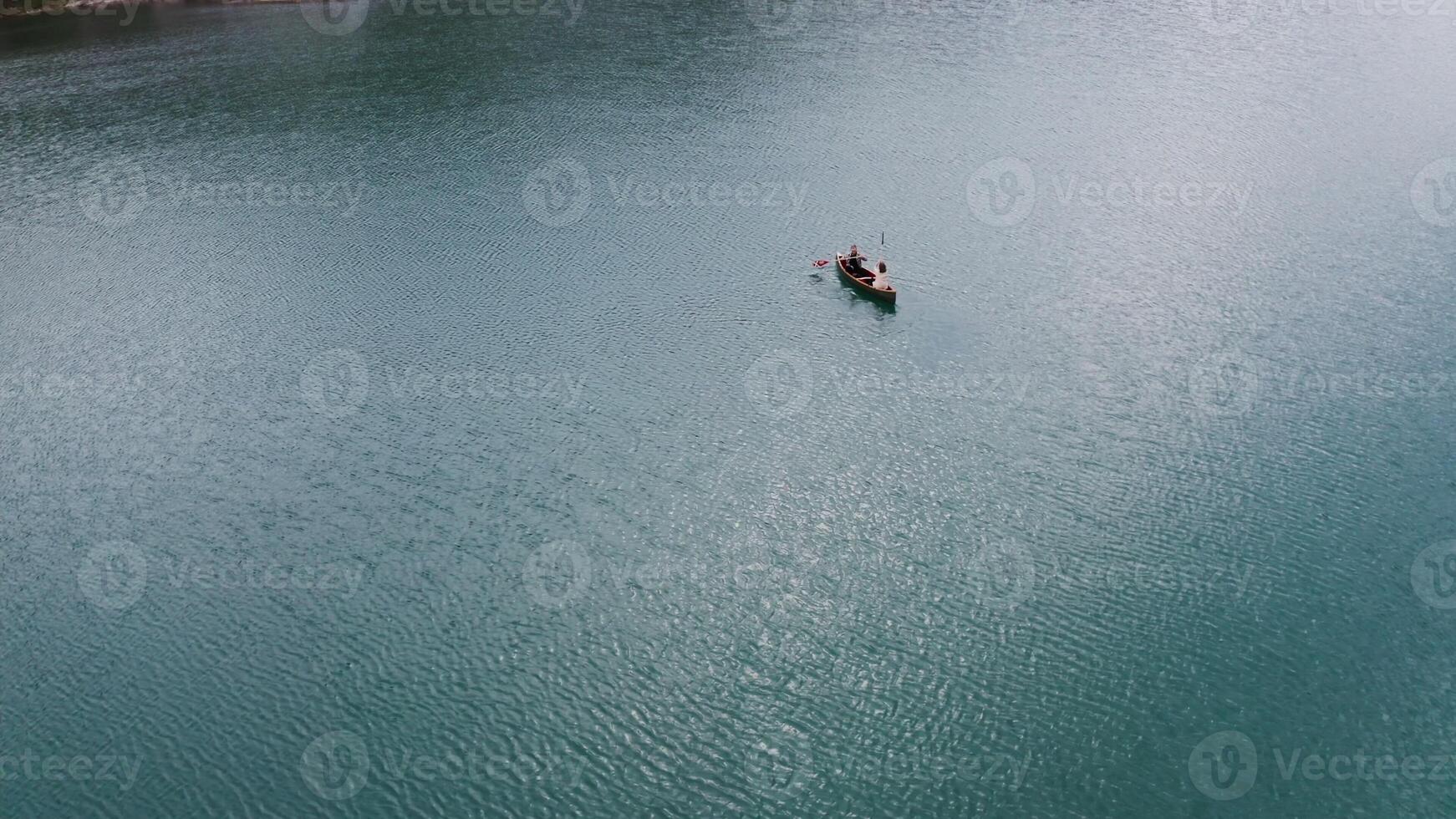 An aerial view of a man in a boat on a lake photo