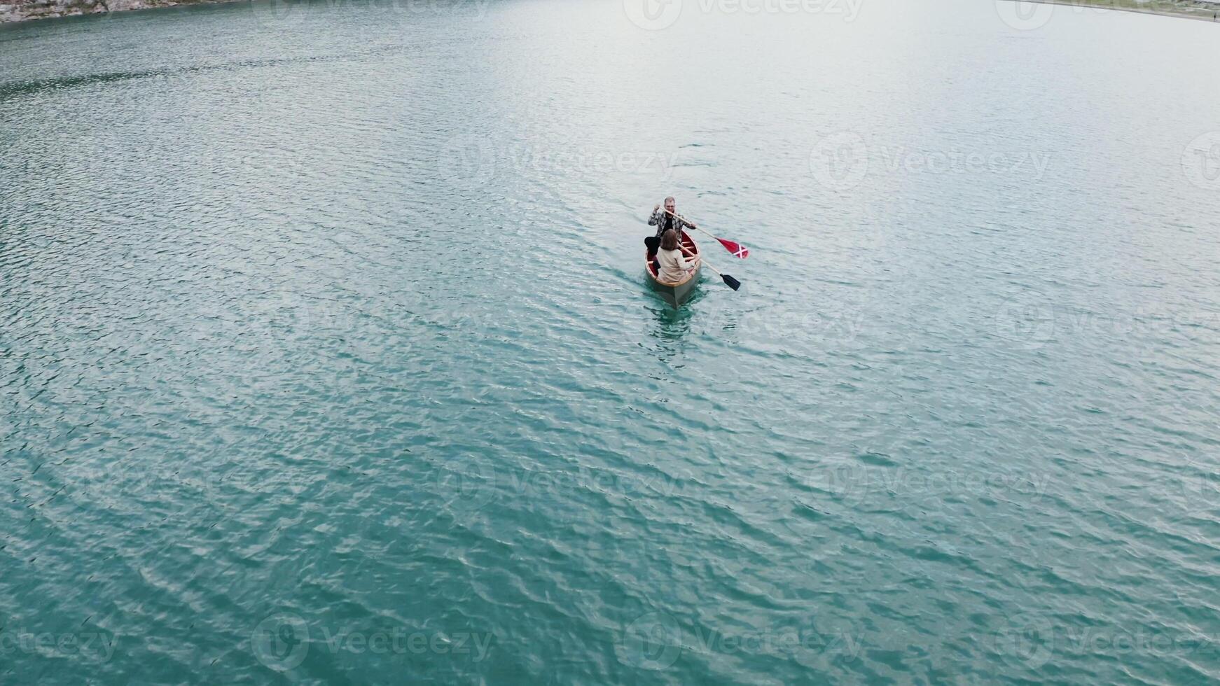 An aerial view of a couple paddling in a canoe photo